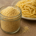 Parmesão vegano com amêndoas - textura granular perfeita em pote de vidro com massa ao fundo