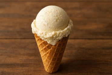 Sorvete de baunilha caseiro cremoso em casquinha, com pontas perfeitas e sementes de baunilha visíveis